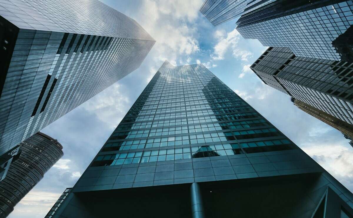 low angle photography of high rise building under white clouds during daytime