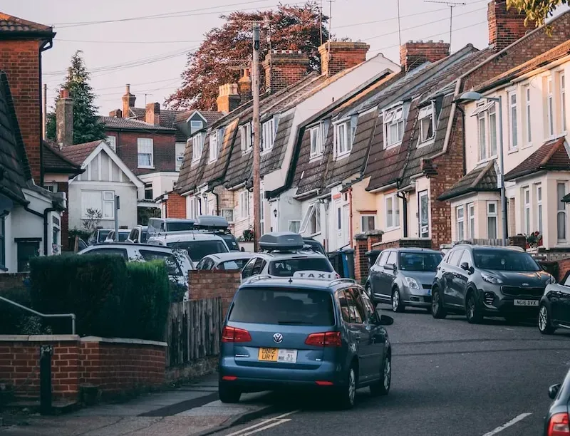 cars parked in front of white and brown concrete house during daytime